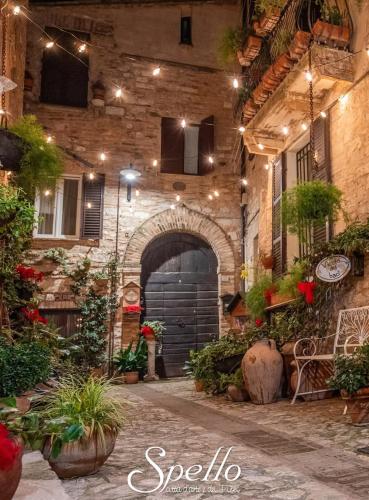 an entrance to a building with a courtyard with plants at Nel vicolo dei Baci - Casa vacanze al Bacio in Spello