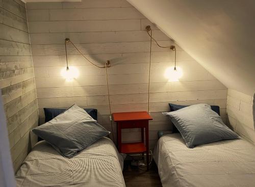 - 2 lits dans une chambre avec une table et 2 lumières dans l'établissement 2 à 4 personnes proche La Roche Bernard, à Férel