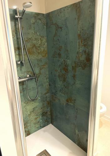 La salle de bains est pourvue d'une douche et d'un mur vert. dans l'établissement 2 à 4 personnes proche La Roche Bernard, à Férel