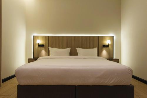 a large white bed in a room with two lights at مهد إن شقق مخدومة جديدة Mahd Inn Hotel in Riyadh