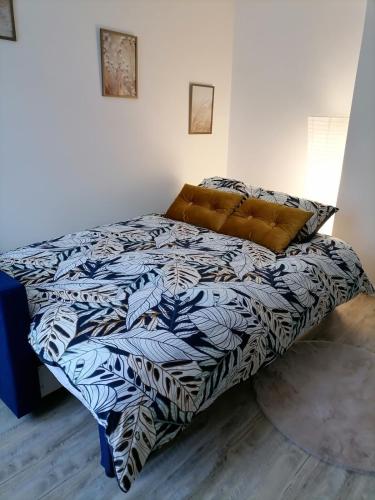une chambre avec un lit avec une couette bleue et blanche dans l'établissement Maison de village Les Marronniers, à Anse