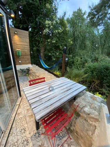 a picnic table and two red chairs on a patio at suite phantastica in Les-Pennes-Mirabeau