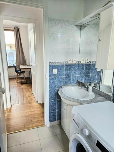 une salle de bain avec un lavabo et une machine à laver dans l'établissement Charmant 3 pièces Rueil Malmaison cœur de ville, à Rueil-Malmaison