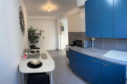 une cuisine avec des armoires bleues et un comptoir dans l'établissement Charmant appartement à proximité de la gare, à Marseille
