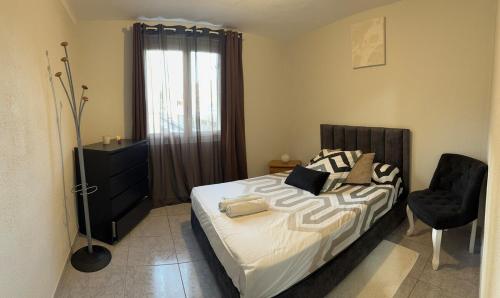 une chambre avec un lit, une chaise et une fenêtre dans l'établissement Charmant appartement à proximité de la gare, à Marseille