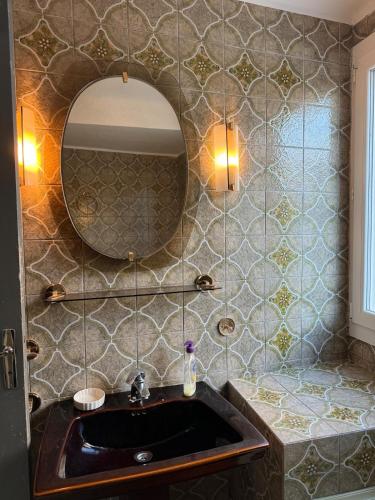 une salle de bain avec un lavabo et un miroir dans l'établissement Charmant appartement à proximité de la gare, à Marseille