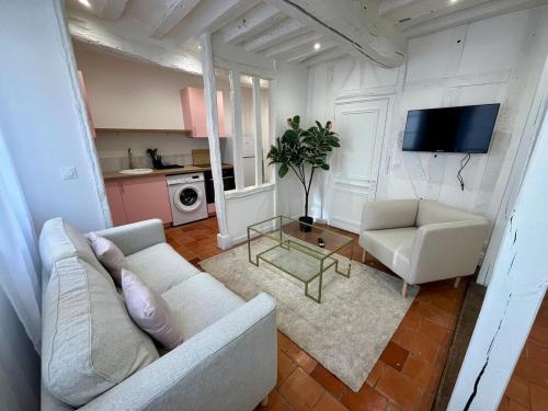 una sala de estar con un sofá y una mesa en La Rose de Vert, en Rouen