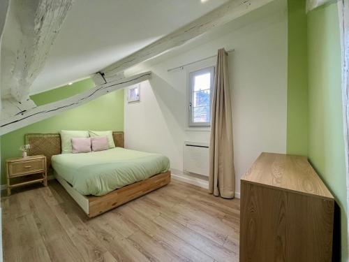 Un dormitorio con una cama con paredes verdes y una ventana en La Rose de Vert, en Rouen