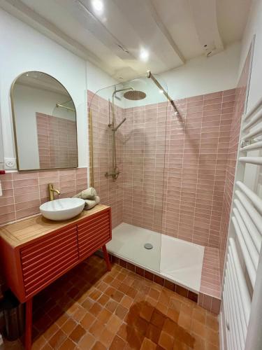 une salle de bain avec un lavabo, une baignoire et un miroir dans l'établissement La Rose de Vert, à Rouen