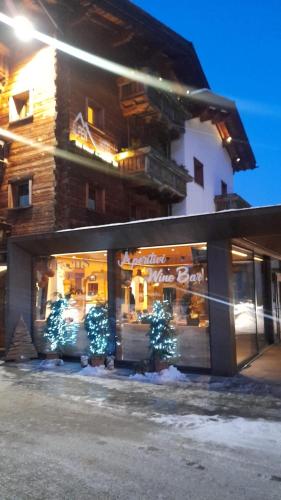 a store with christmas trees in front of a building at Alpen Hotel Chalet in Valdidentro