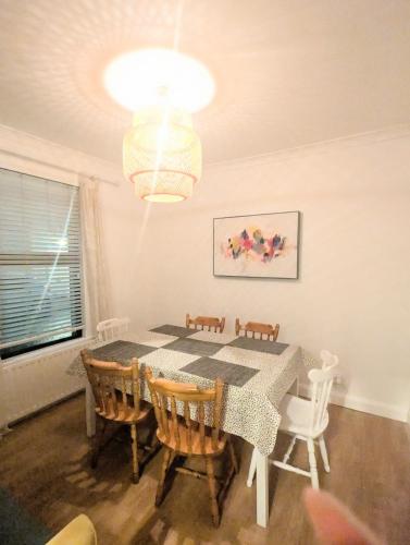 a dining room with a table and chairs and a chandelier at Ivy Townhouse Derry in Derry Londonderry