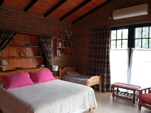 a bedroom with a large bed with pink pillows at De la Sierra in Sierra de la Ventana