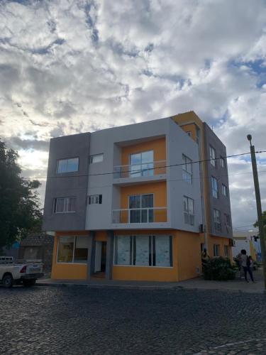un edificio su una strada con un cielo nuvoloso di Vannimar t2 a Porto Novo
