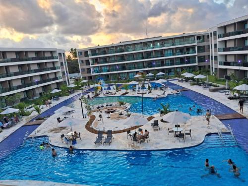 a large swimming pool with people in a resort at Malia Beach 302 D - Muro Alto - Porto de Galinhas in Porto De Galinhas