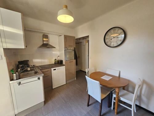 a kitchen with a table and a clock on the wall at proche centre calme jardin privé in Nantes