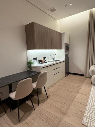 a kitchen with a table and chairs in a room at مهد إن شقق مخدومة جديدة Mahd Inn Hotel in Riyadh