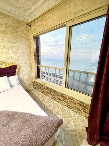 a bedroom with a large window with a view of the ocean at Sporting star in Alexandria