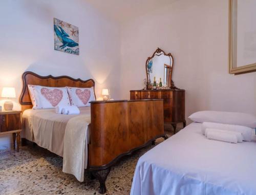 a bedroom with two beds and a dresser with a mirror at Villetta Tramontana 30 Metri Dalla Spiaggia in Torre Specchia Ruggeri