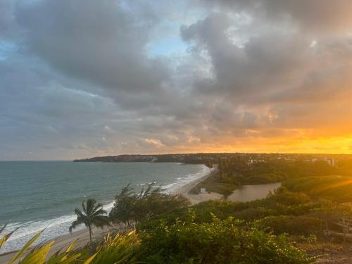 a view of a beach at sunset with the ocean at Casa de praia em Jacumã, carapibus in Conde