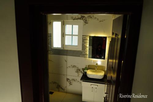 a bathroom with a sink and a mirror at Riverine Residence in Nu Chid