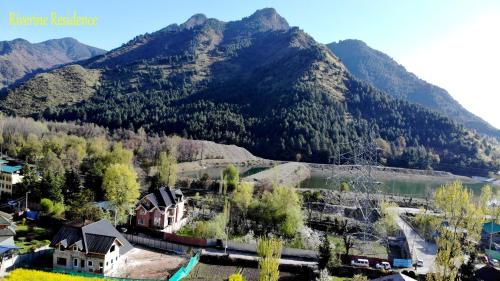 a village in front of a mountain with a river at Riverine Residence in Nu Chid