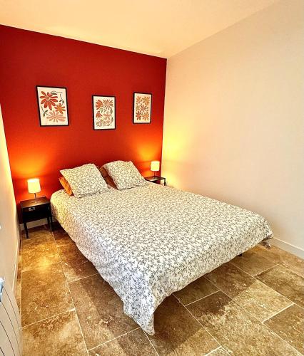 une chambre avec un lit et un mur rouge dans l'établissement T2 - Tendance avec place de parking devant la porte d'entrée, à Orléans