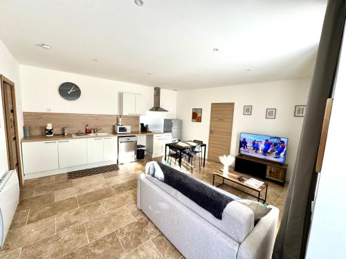 un salon avec un canapé et une cuisine dans l'établissement T2 - Tendance avec place de parking devant la porte d'entrée, à Orléans