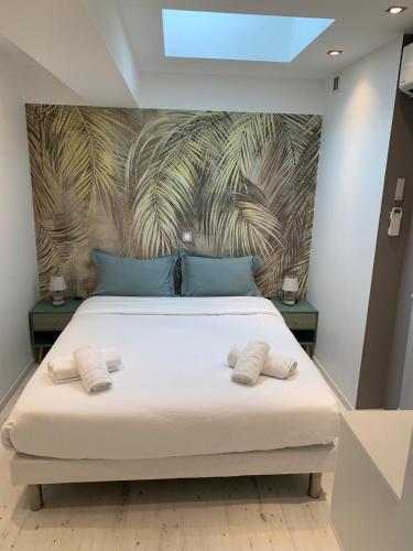 une chambre avec un lit avec deux serviettes dessus dans l'établissement Petit Saint James Croisette, à Cannes
