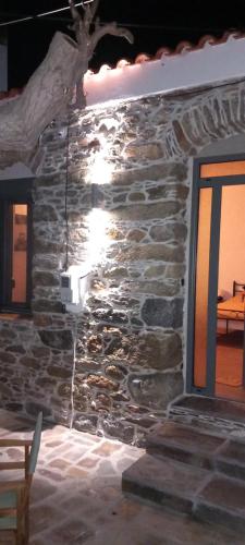 a stone wall of a building with a light on it at Vounios house in Manganítis