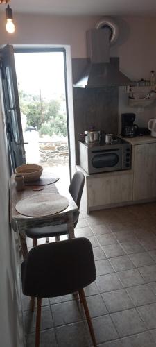 a kitchen with a table and a kitchen with a stove at Vounios house in Manganítis