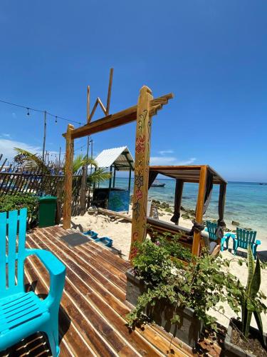 a wooden deck with blue chairs on the beach at Cabañas W Beach in Cartagena de Indias
