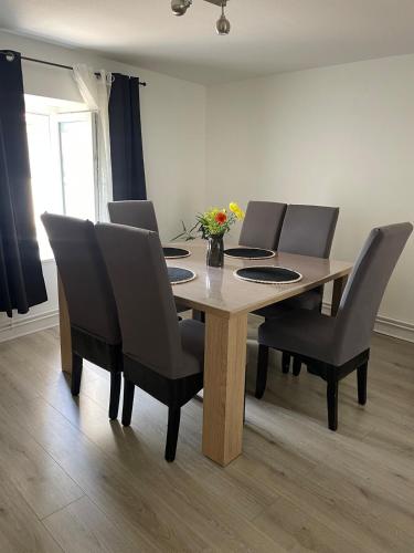 - une table à manger avec des chaises et une table fleurie dans l'établissement Duplex cosy, à Vesoul