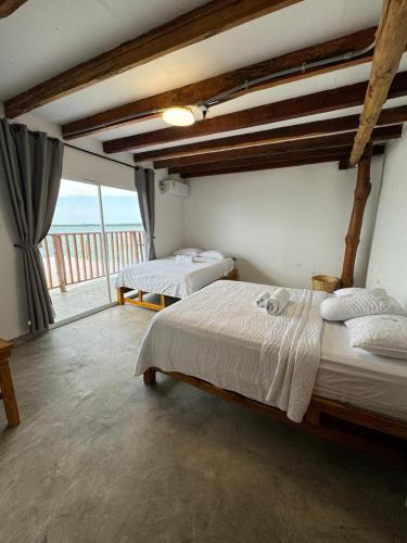 a bedroom with two beds and a large window at Cabañas W Beach in Cartagena de Indias