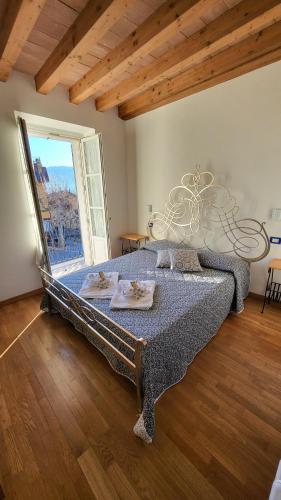 a large bed in a room with a large window at Balconi san Giorgio in Varenna