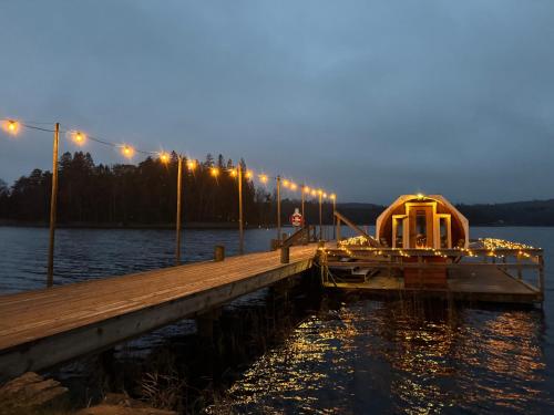 a dock with a boat on the water at night at Stuga nära Ullared Mitt i Åkulla bokskogar in Rolfstorp