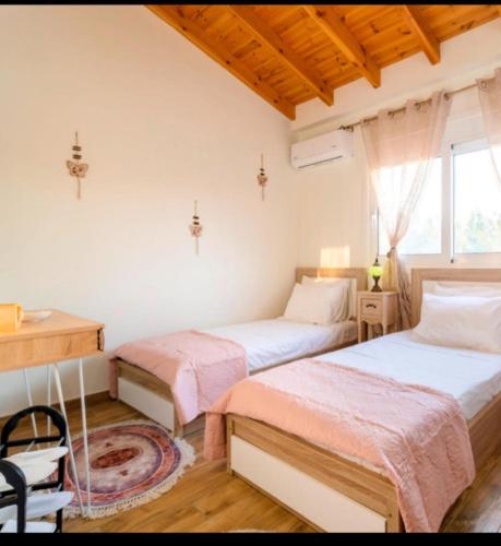 a bedroom with two beds and a desk and a window at Blue Waves House 2 in Soroni