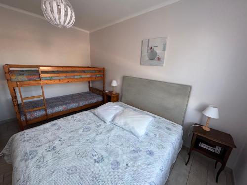 ein Schlafzimmer mit einem Bett und einem Etagenbett in der Unterkunft Notre Dame de Monts proche plage in Notre-Dame-de-Monts