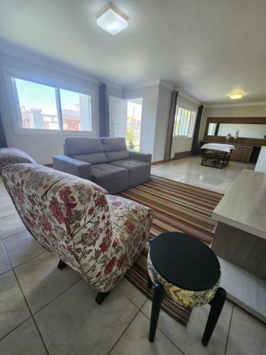 a living room with a couch and a table at Casa veraneio em Xangri-Lá in Xangri-lá