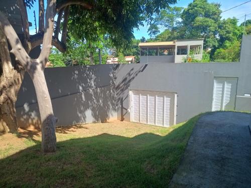 a house with a wall and a garage at Casa de Praia da Lara in Piúma