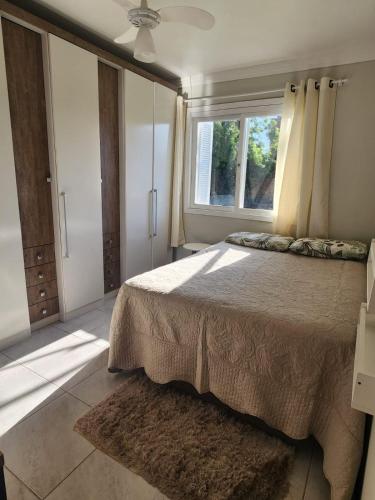 a bedroom with a large bed and a window at Casa veraneio em Xangri-Lá in Xangri-lá