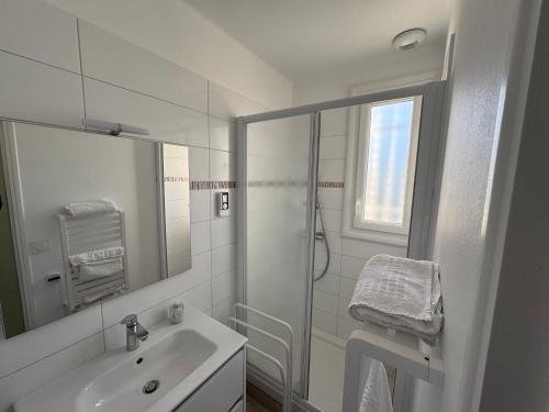 ein weißes Badezimmer mit Waschbecken und Dusche in der Unterkunft Notre Dame de Monts proche plage in Notre-Dame-de-Monts