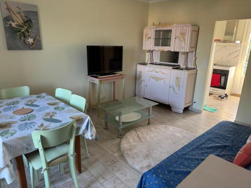 un salon avec une table et une télévision dans l'établissement Notre Dame de Monts proche plage, à Notre-Dame-de-Monts