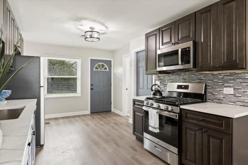 a kitchen with a stove and a microwave at Westchester Retreat King bed in Westchester