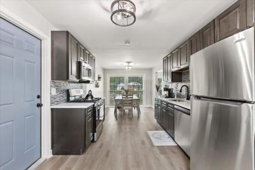 a kitchen with a stainless steel refrigerator and a table at Westchester Retreat King bed in Westchester