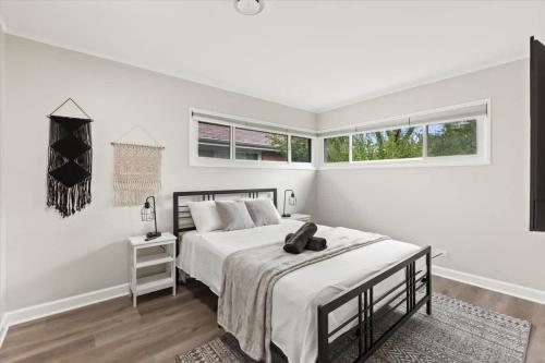 a white bedroom with a bed and two windows at Westchester Retreat King bed in Westchester
