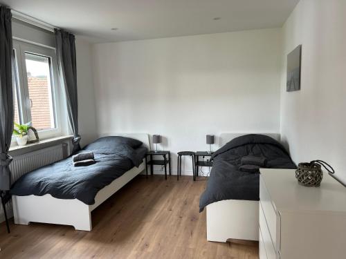 a bedroom with two beds and a table at TeamStay Apartments & Boardinghouses in Hellstein