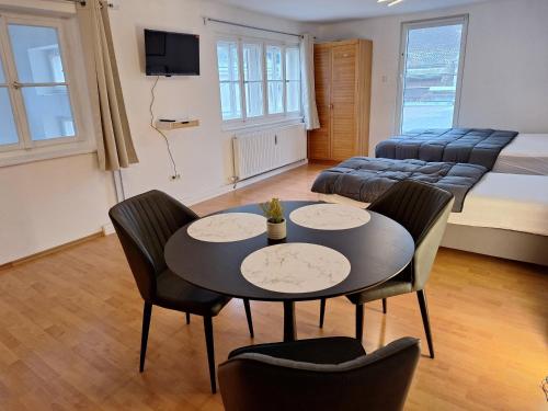 a living room with a table and chairs and a couch at Apartment im Zentrum von Wels - Self Check-in in Wels