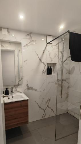 a bathroom with a marble wall with a sink and a shower at Quintinha das Achadas in Achadas da Cruz