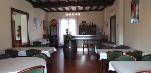 a dining room with tables and chairs and a piano at L'auberge d'audressein in Audressein