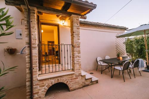 a patio with a table and a balcony at Agriturismo Angeli Sognanti in Cossignano
